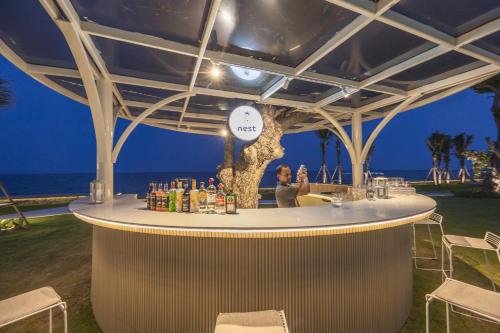 a woman sitting at a bar at the beach at night at Aviyana Hua Hin in Cha Am