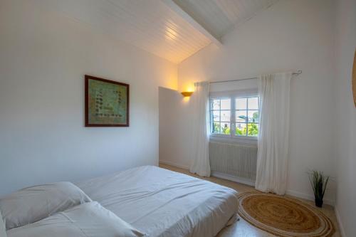 une chambre blanche avec un lit et une fenêtre dans l'établissement Villa Lumineuse avec Piscine Chambres OU Villa, à Saint-Georges-dʼOrques