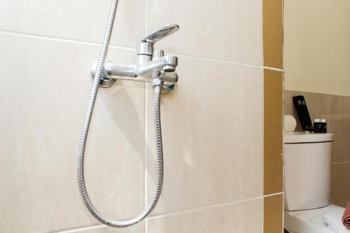 eine Dusche mit einem Schlauch in einem Badezimmer in der Unterkunft Comfortable and Homey 3BR at Meikarta Apartment By Travelio in Cikarang