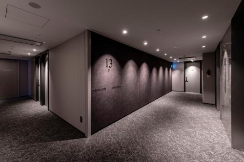 a hallway with a wall with a clock on it at HOTEL TORIFITO KANAZAWA in Kanazawa
