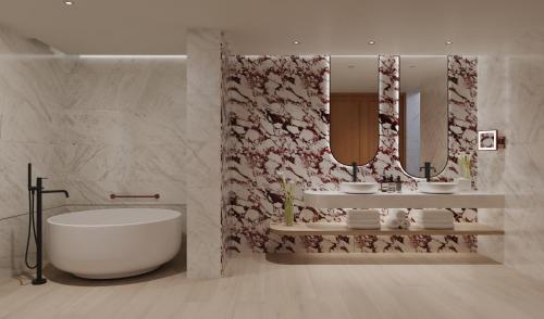 a bathroom with a tub and two sinks and a mirror at Delano Dubai at Bluewaters in Dubai