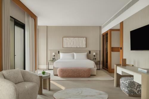 a hotel room with a bed and a tv at Delano Dubai at Bluewaters in Dubai