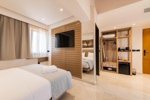 a bedroom with a bed and a tv in a room at The Wine Hotel in Rhodes Town