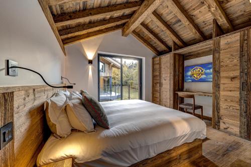a bedroom with a large bed in a room with wooden ceilings at Chalet Cotes du Lavancher in Chamonix-Mont-Blanc