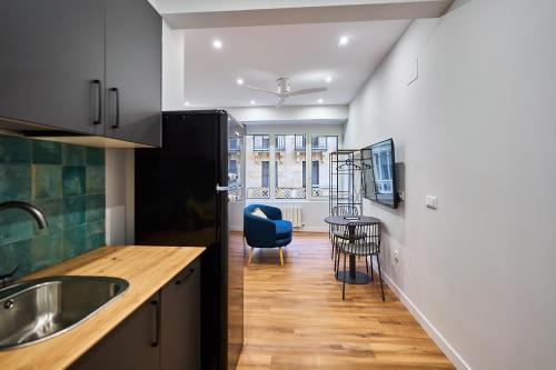 a kitchen with a sink and a blue chair at Apartamentos Esperanza by gaiarooms in Salamanca