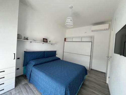 - une chambre avec un lit bleu et une télévision dans l'établissement Gassa d Amante Borghetto Santo Spirito, à Borghetto Santo Spirito