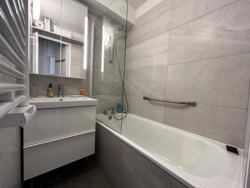 La salle de bains est pourvue d'une baignoire blanche, d'un lavabo et d'une baignoire. dans l'établissement Résidence Plattieres - PLATTIERES 15 MAE-6351, à Les Allues