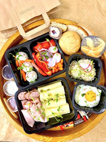 three trays of food on a wooden table at VIP Apartamenty Stara Polana 2 in Zakopane