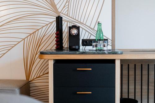 a counter with a bottle and a drink on it at Avita Resort Bad Tatzmannsdorf in Bad Tatzmannsdorf