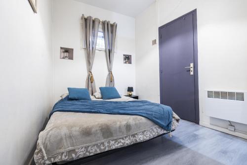 une chambre avec un lit avec des draps bleus et une fenêtre dans l'établissement Comédie 1 - Apt centre ville de Perpignan, à Perpignan