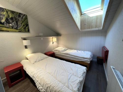 Cette petite chambre comprend deux lits et une lucarne. dans l'établissement Résidence Plattieres - PLATTIERES 15 MAE-6351, à Les Allues