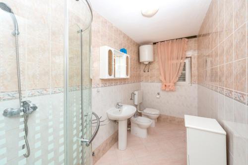 a bathroom with a shower and a toilet and a sink at Holiday House Lido in Orebić