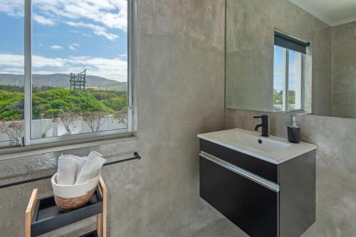 a bathroom with a sink and a window at 49 Whalerock in Hermanus