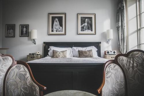 a bedroom with a bed with three pictures on the wall at Southernhay House Hotel in Exeter