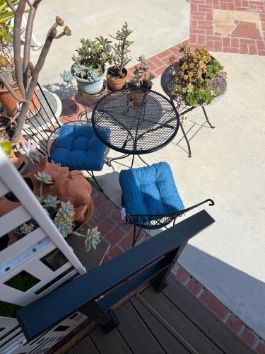 a patio with a table and chairs and potted plants at The Hub in Del Aire