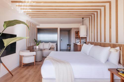 a bedroom with a white bed and a living room at ME Marbella by Meliá in Marbella