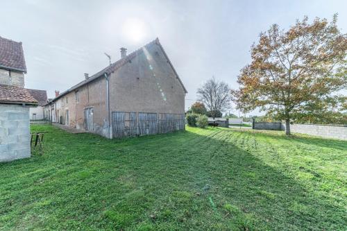 an old barn with a grass yard in front of it at La dépendance de la Pointe - 12 voyageurs in Saint-Yan