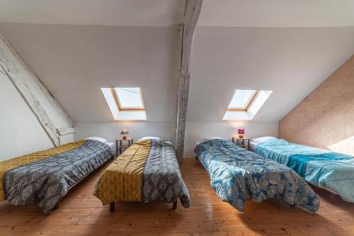 three beds in a room with three windows at La dépendance de la Pointe - 12 voyageurs in Saint-Yan