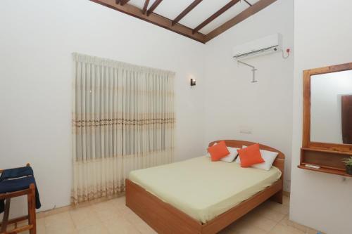 ゴールにあるThuli villa 3 bedroom villaのベッドルーム(ベッド1台、鏡付)