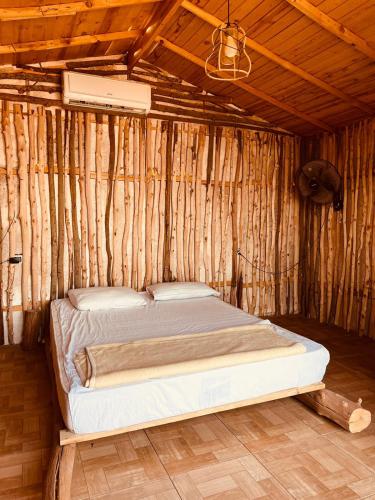 Un dormitorio con una cama en una pared de madera. en Anne Sinai best camp, en Nuweiba
