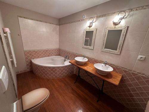 une salle de bain avec deux lavabos et une baignoire dans l'établissement Charmant duplex des tilleuls, à Demange-aux-Eaux