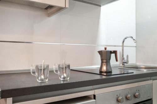 two glasses sitting on a counter in a kitchen at Apartamentos Bellamar in Barbate