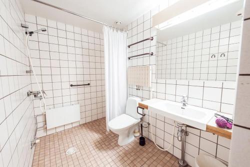 a bathroom with a toilet and a sink at Forenom Aparthotel Lahti in Lahti
