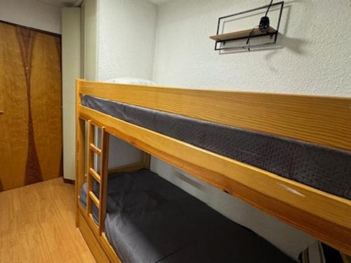 Ce lit superposé en bois se trouve dans un dortoir doté d'une porte. dans l'établissement Studio charmant proche pistes et commerces avec parking, balcon, animaux acceptés - FR-1-445-210, à Montgenèvre