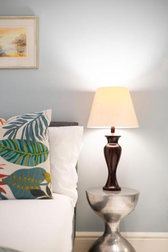 a lamp on a table next to a bed at The Willets Boutique Hotel in Simon's Town in Simonʼs Town