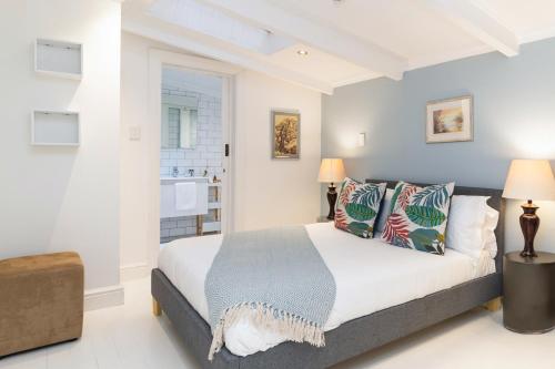 a bedroom with a large bed with pillows at The Willets Boutique Hotel in Simon's Town in Simonʼs Town