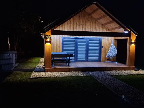 a gazebo with a bench and a blue door at Naujai įrengtas atostogų namelis in Anykščiai