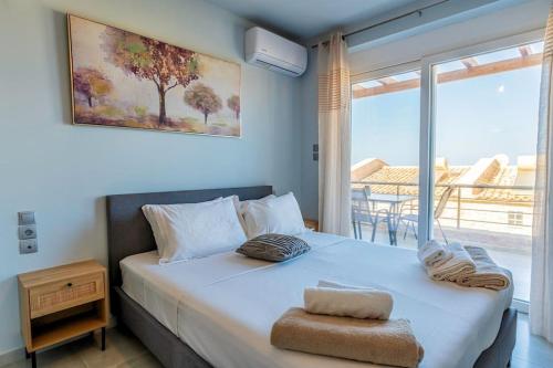 sypialnia z łóżkiem i widokiem na ocean w obiekcie Zefyros Suite , Seafront retreat ! w mieście Panormos