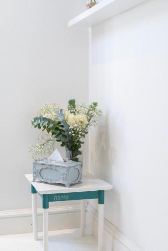 a table with a vase of flowers on it at The Willets Boutique Hotel in Simon's Town in Simonʼs Town