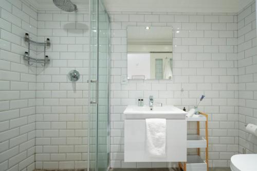 a bathroom with a sink and a glass shower at The Willets Boutique Hotel in Simon's Town in Simonʼs Town