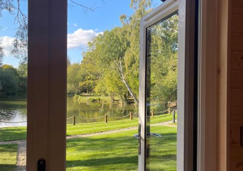 a view from a door looking out at a lake at Great Hallingbury Manor & Lodges London Stansted in Bishops Stortford