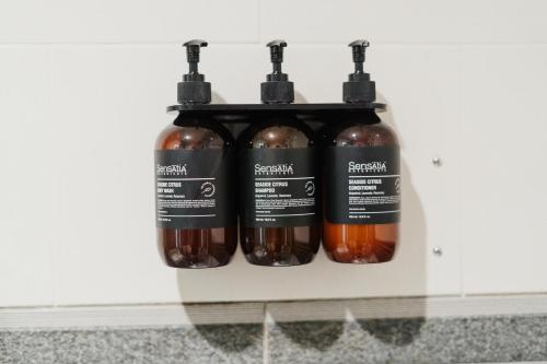 a shelf with four bottles of sauce on it at You Suite Seminyak in Legian