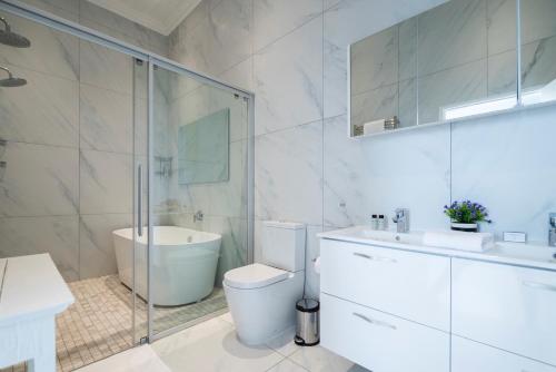 a bathroom with a toilet and a sink and a shower at The Willets Boutique Hotel in Simon's Town in Simonʼs Town