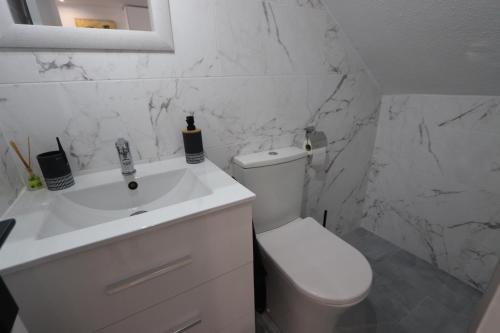 a white bathroom with a toilet and a sink at Torrevieja Spectacular Townhouse in Torrevieja