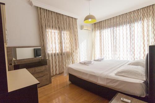 a bedroom with a large bed and a television at Peanut House by HolidayKeys in Kérynia