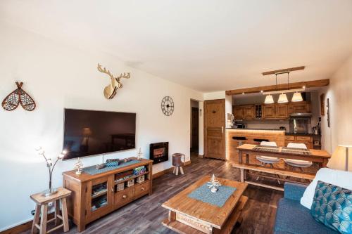 un salon avec un canapé et une télévision dans l'établissement Apartment - Le Cerf Blanc, à Praz-sur-Arly