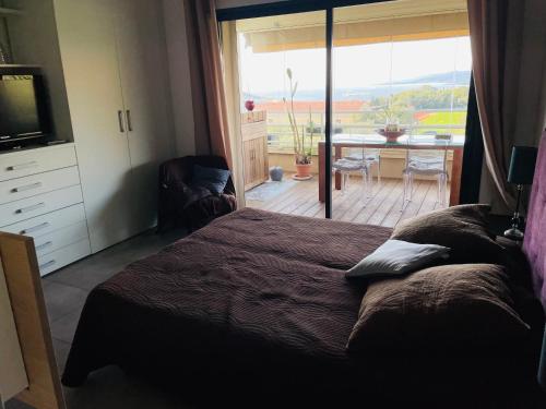 - une chambre avec un lit et une vue sur une terrasse dans l'établissement appartement Vue mer époustouflante, à Propriano