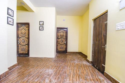 two doors in an empty room with wood floors at FabHotel Airport Residency I in Khandagiri