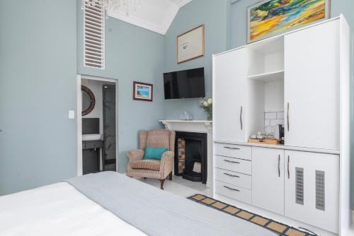 a bedroom with a bed and a desk and a chair at The Willets Boutique Hotel in Simon's Town in Simonʼs Town