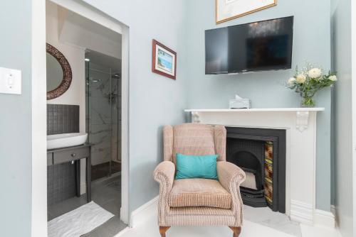 a living room with a chair and a fireplace at The Willets Boutique Hotel in Simon's Town in Simonʼs Town