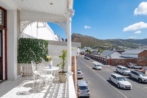 a balcony with a table and chairs and a street at The Willets Boutique Hotel in Simon's Town in Simonʼs Town