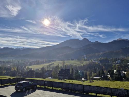 a truck driving down a road with mountains in the background at Good Morning Giewont & JACUZZI in Kościelisko