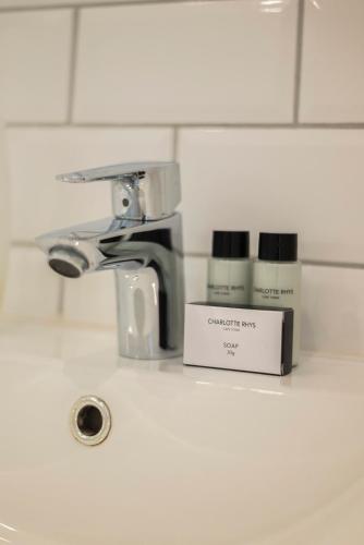 a bathroom sink with a faucet and a box ofodorizers at The Willets Boutique Hotel in Simon's Town in Simonʼs Town