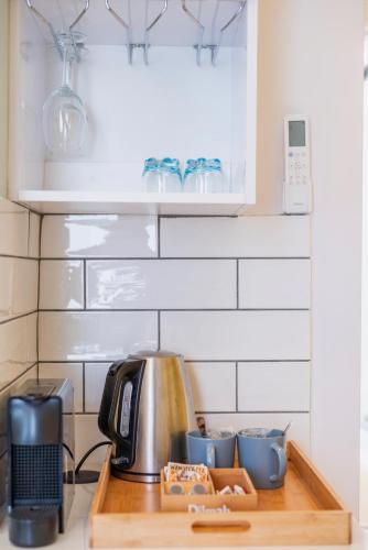 a kitchen counter top with a tea kettle and dishes at The Willets Boutique Hotel in Simon's Town in Simonʼs Town