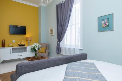 a living room with a couch and a tv at The Willets Boutique Hotel in Simon's Town in Simonʼs Town