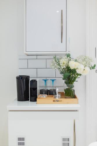 a kitchen counter with a vase of flowers and a sink at The Willets Boutique Hotel in Simon's Town in Simonʼs Town